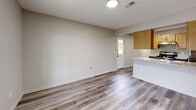 Located at 1800 Commerce Pkwy in La Grange, Kentucky, this one-bedroom, two-bathroom unit is thoughtfully laid out across a single floor. Light-toned luxury vinyl plank flooring runs throughout, providing a clean, cohesive look across every room.

The heart of the unit is an open-concept space combining the living room, dining area, and kitchen. The kitchen is well-equipped with light wood cabinetry, stainless steel appliances including a refrigerator and dishwasher, a coil-burner range, a double-basin sink, and light-toned laminate countertops. A peninsula with a granite-style countertop separates the kitchen from the living and dining areas, adding functional counter space and a natural division. A door in the living area provides exterior access and brings in natural light.

The bedroom is a comfortable, well-proportioned room with a window offering neighborhood views. The unit includes two full bathrooms — one featuring a dark wood vanity with ample storage and a tub/shower combination. Three closets provide generous storage throughout, and a dedicated laundry area adds everyday convenience. The hallway connects all rooms efficiently. Neutral wall tones and consistent flooring give the unit a clean, move-in ready feel.