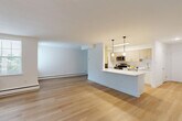 Located at 421 E Lancaster Ave in Wayne, PA, this well-appointed two-bedroom, one-bathroom residence offers a thoughtfully designed single-floor layout with a generous overall footprint. The open-concept living and dining area is anchored by light-toned hardwood-style flooring that flows throughout the main spaces, creating a bright and cohesive atmosphere. Large windows allow natural light to fill the rooms, enhancing the clean, modern aesthetic defined by crisp white walls and contemporary finishes.

The kitchen is a standout feature, showcasing sleek quartz countertops, a peninsula with pendant lighting, light wood cabinetry, stainless steel appliances including a gas range and microwave, and a classic hexagonal tile backsplash — a well-equipped space suited for both everyday cooking and entertaining.

The primary bedroom is generously sized, while the second bedroom offers comfortable dimensions, both carpeted for warmth and comfort. A versatile den adds flexible living space. The full bathroom features a tub/shower combination with white subway tile surround and brushed nickel fixtures. A dedicated laundry area houses a stacked washer and dryer unit with adjacent shelving. Two closets provide practical storage throughout. The space combines modern updates with functional design in a desirable Wayne location.