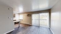 Located at 2890 S Ninth St in Kalamazoo, Michigan, this two-bedroom, one-bathroom residence offers a practical and well-appointed single-floor layout. The living room serves as the central gathering space, featuring durable wood-style plank flooring, neutral-toned walls, and a large sliding glass door fitted with vertical blinds that floods the room with natural light and provides views of the surrounding greenery. A wall-mounted HVAC unit and baseboard heating ensure year-round comfort.

The galley-style kitchen is a functional highlight, showcasing rich dark cabinetry with brushed nickel hardware, light countertops offering ample workspace, and stainless steel appliances including a refrigerator and electric range. A window above the counter brings in additional natural light.

Both bedrooms are carpeted for warmth and comfort, each featuring a closet with built-in shelving and windows with exterior views. The primary bedroom provides a comfortable retreat with dedicated closet storage.

The full bathroom is finished with wood-style tile flooring, a dark vanity with a white countertop, and a tub-shower combination. A hallway connects the living areas to the bedrooms and bathroom, completing this efficient and move-in-ready floor plan.