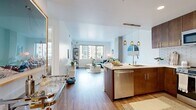 This contemporary 570 square foot apartment in Denver offers a thoughtfully designed living space. The open-concept layout seamlessly integrates the living room, kitchen, and dining area, creating a spacious feel despite the compact footprint. The living room is anchored by a comfortable blue sectional sofa and features large windows that flood the space with natural light and offer urban views.

The kitchen boasts rich wood cabinetry, stainless steel appliances, and a subway tile backsplash, blending functionality with style. The 110 square foot bedroom provides a cozy retreat with a large window, plush carpeting, and ample closet space. A round mirror and sleek console add a touch of elegance.

The bathroom continues the modern aesthetic with clean lines, a floating vanity, and a glass-enclosed shower. Throughout the apartment, hardwood floors unify the space, while strategically placed recessed lighting enhances the ambiance. Thoughtful details like plants, artwork, and decorative accents create a welcoming atmosphere in this efficiently designed urban dwelling.