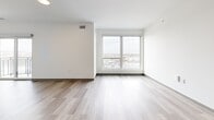 Located at 2132 Stokes Blvd in Cleveland's University Circle area, this one-bedroom, one-bathroom unit offers a thoughtfully designed modern layout. Light-toned wood-style flooring runs throughout, creating a bright and cohesive feel across every room.

The open-concept kitchen and living area forms the heart of the unit. The kitchen is outfitted with sleek gray cabinetry, white subway tile backsplash, white quartz countertops, stainless steel appliances including a refrigerator and dishwasher, and ample upper and lower cabinet storage. The adjacent living area is generously proportioned and bathed in natural light from a large picture window and a sliding glass door that opens to a private balcony with open city views.

The bedroom continues the clean aesthetic with light flooring, a sliding glass door to the balcony, and a dedicated closet with louvered doors. The bathroom features marble-look tile flooring, a gray vanity with white countertop, a large mirror, and matte black hardware and accessories for a contemporary finish. A dedicated laundry area completes the unit's practical offerings.

Throughout, crisp white walls, recessed lighting, and a neutral palette contribute to a clean, modern ambiance well-suited for comfortable urban living.