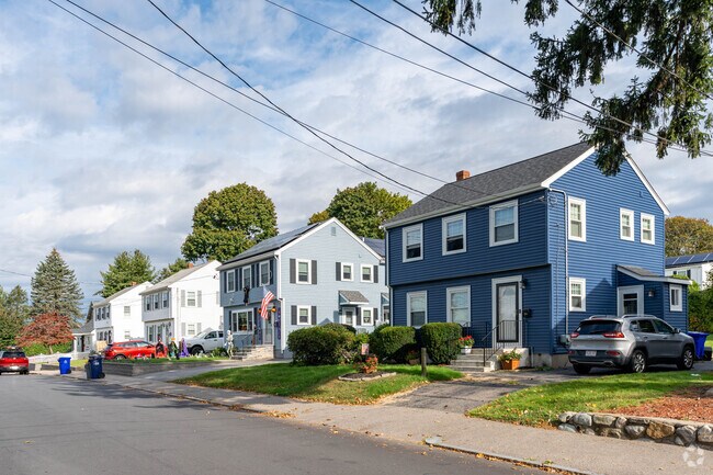 A row of colonial homes with private driveways and yard spaces line the streets of Hyde Park.