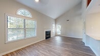 Located at 9807 Gable Ridge Terrace in Rockville, MD, this two-floor residence offers a well-designed layout across two distinct levels. The main floor serves as the heart of the home, highlighted by a dramatic vaulted ceiling that creates a striking sense of vertical space in the living room. A classic fireplace with white surround anchors the room, while large windows—including an arched transom window—flood the space with natural light and offer views of surrounding greenery. Wood-look flooring extends throughout the main level, lending a cohesive, contemporary feel.

The kitchen is thoughtfully designed with white shaker cabinetry, quartz countertops, a peninsula with an undermount sink, and a full suite of stainless steel appliances including a gas range, microwave, and refrigerator. A half bathroom on the main level provides added convenience for guests.

A staircase leads to the upper level, where the primary bedroom is carpeted and generously proportioned, featuring a walk-in closet and direct access to a full bathroom complete with a tub/shower combination and quartz vanity. Additional windows in the bedroom offer natural light and outdoor views. The overall palette of neutral tones and clean finishes creates a bright, move-in-ready atmosphere throughout.