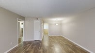 Located at 2103 Meadow Cir in Atlanta, GA, this single-story home offers four bedrooms, two bathrooms, and a practical layout that efficiently utilizes its interior space. The home features wood-look plank flooring throughout the main living areas, complemented by neutral warm-gray walls and white trim that create a clean, cohesive aesthetic.

The living room is bright and welcoming, with a front-facing window that allows natural light to fill the space. It connects naturally to the dining area, which is distinguished by a pendant light fixture and a chair rail detail along the walls. Two hallways provide organized circulation throughout the home.

The kitchen has been updated with white shaker-style cabinetry, light granite-look countertops, a tiled backsplash, stainless steel dishwasher, and a window overlooking the exterior—providing both functionality and natural light.

The bedrooms are carpeted for comfort, each featuring closets with wire shelving for storage. The bathrooms include a tub-shower combination with white tile surround. A utility area with an electrical panel is also accessible. The textured ceilings are consistent throughout, adding a traditional character to this well-maintained home.