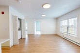 Located at 8 Admiral Harry Rich Drive in Brunswick, Maine, this two-bedroom, one-bathroom residence offers a well-designed single-floor layout with a clean, modern aesthetic throughout. The open-concept kitchen and living area serves as the heart of the home, featuring light hardwood-style flooring, round flush-mount ceiling fixtures, and abundant natural light from multiple windows with blinds. The kitchen is equipped with stainless steel appliances including a refrigerator, range, microwave, and dishwasher, complemented by rich dark-toned cabinetry, light countertops, and a classic subway tile backsplash. A peninsula with a stainless sink adds both workspace and a natural divider between the kitchen and living area. Baseboard heating and a wall-mounted mini-split unit provide year-round climate control. The two bedrooms are carpeted in neutral tones, with soft blue-grey walls that create a calm atmosphere; the primary bedroom includes a closet. The bathroom features hardwood-style flooring, a wood-tone vanity with a white countertop, and a large mirror. A hallway connects the living spaces efficiently, and an in-unit stacked washer and dryer adds everyday convenience to this thoughtfully appointed Brunswick home.