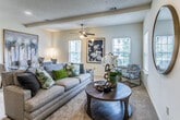 The Cape Poge, located in Memphis, TN 38125, presents a thoughtfully designed one-bedroom, one-bathroom single-story residence. The open-concept living and dining area forms the heart of the home, characterized by plush wall-to-wall carpeting, a textured ceiling, and a ceiling fan that anchors the space. Multiple windows along the perimeter flood the room with natural light while offering views of the surrounding greenery. Recessed lighting complements the ambient glow throughout.

The dining area flows seamlessly from the living space, providing a natural transition ideal for everyday living and entertaining. The kitchen, separated by a hallway entry, features warm medium-toned cabinetry, black appliances including a refrigerator, range, and built-in microwave, and durable wood-look flooring.

The bedroom is generously proportioned, with carpet underfoot, a ceiling fan overhead, and multiple windows that bring in natural light and outdoor views. A spacious walk-in closet with double hanging rods and built-in shelving provides ample storage.

The bathroom includes a vanity with rich cabinetry, light countertops, and wood-look flooring, offering a clean and functional design throughout.
