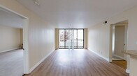 Located at 117 E San Carlos St in San Jose, California, this single-floor unit offers a thoughtfully arranged layout with a clean, neutral aesthetic throughout. The living area is a standout feature, finished with smooth hardwood-style flooring and framed by expansive floor-to-ceiling sliding glass doors that open onto a private balcony. Views of surrounding trees provide a refreshing natural backdrop, and abundant natural light fills the space, enhancing its open, airy feel.

The kitchen is positioned in an open-concept arrangement adjacent to the living area, centered around a peninsula with granite-style countertops. White cabinetry provides ample storage, and the space is equipped with a full suite of appliances including a refrigerator, range, and microwave. A stainless steel sink and additional counter space add to the kitchen's functionality.

The bedrooms are carpeted for comfort and each features mirrored sliding closet doors that contribute to a sense of spaciousness. Large windows with balcony access in the bedrooms allow for continued natural light and outdoor views.

The bathrooms are finished with hardwood-style flooring, white vanity cabinetry, granite-style countertops, and a tub-shower combination, offering a clean and practical design. Throughout the unit, warm beige tones and consistent finishes create a cohesive and welcoming ambiance.