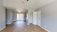 This single-floor, 2-bedroom, 2-bathroom home offers a thoughtfully designed layout that balances comfort and functionality. The living area greets you with vaulted ceilings, wood-look flooring, and a ceiling fan, creating an airy and open atmosphere. A sliding glass door floods the space with natural light and provides access to the outdoors, while a coat closet near the entry adds convenient storage.

The kitchen features a peninsula-style breakfast bar that opens to the main living area, white cabinetry with modern hardware, light quartz-style countertops, a subway tile backsplash, and black appliances including a refrigerator and dishwasher. A window above the sink brings in additional natural light.

The primary bedroom is a spacious retreat with tall ceilings, a ceiling fan, wood-look flooring, and a large window with outdoor views. The second bedroom offers plush carpeting, a window with natural light, and sliding glass door access. Both bedrooms are complemented by closet storage. The two bathrooms are clean and functional, each featuring a tub-shower combination with chrome fixtures and wood-look flooring. Soft gray walls and white trim carry a cohesive, neutral palette throughout the entire home.
