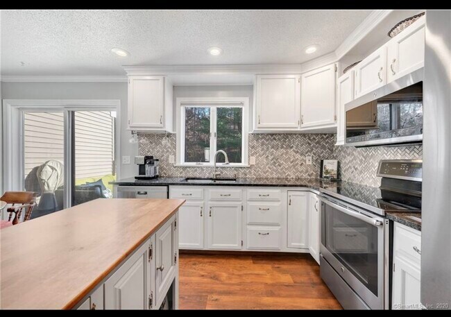 Beautifully updated kitchen with granite countertops and newer stainless steel appliances. - 62 Mallard Ct