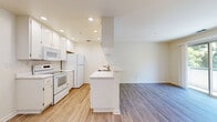 Located in Danville, CA, this single-floor residence offers a thoughtfully arranged layout with two bedrooms, a hallway, and a dedicated closet. The open-concept kitchen and living area form the heart of the home, featuring durable hardwood-style flooring, white cabinetry, recessed lighting, and a peninsula with a built-in sink — ideal for both cooking and casual dining. The living area flows naturally from the kitchen, providing a bright, connected space with a clean, neutral palette throughout.

A central hallway connects the main living areas to the private sleeping quarters. Both bedrooms feature soft carpeting, ceiling fans with light fixtures, and windows that frame views of surrounding greenery, allowing ample natural light. The primary bedroom offers a comfortable footprint well-suited for a full furniture arrangement. A sliding-door closet with a hanging rod provides convenient storage in one of the bedrooms.

The interior finishes maintain a consistent, clean aesthetic with warm cream-toned walls and white trim throughout. The HVAC system includes ceiling vents for climate control, and a thermostat is conveniently located in the hallway. Overall, the space presents a practical and inviting layout suited for everyday living in the desirable Danville community.