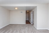 This two-story space in Macon, Georgia offers a practical and comfortable layout across two well-defined levels connected by a carpeted staircase with a wood handrail. The main level features hardwood flooring that flows through the entry hallway and into the kitchen area, providing a warm, durable foundation. The kitchen is equipped with white cabinetry, granite-style countertops, black appliances including an electric range and dishwasher, and a sink positioned beneath a window that allows natural light to filter in.

The living areas are carpeted and generously proportioned, with one room featuring a set of French doors that open to the outdoors, enhancing the sense of connectivity to the exterior. A bathroom on this level includes tile flooring, a tub-shower combination, a toilet, and a vanity. Multiple bedrooms are carpeted and include ceiling fans with light fixtures and windows that bring in natural light. One bedroom features a built-in shelved closet, adding useful storage. The upper level is accessible via the interior staircase and continues the consistent neutral color palette found throughout. Overall, the space presents a straightforward, functional design with a clean, understated aesthetic.