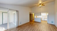 Located at 2404 Allen St. in Kelso, WA, this single-floor, 3-bedroom, 2-bathroom home offers a well-organized layout with a comfortable, functional design throughout. The open-concept living and dining area is a highlight, featuring soaring vaulted ceilings, a ceiling fan, and light wood-style flooring that extends throughout the main living spaces. Large windows and a sliding glass door flood the room with natural light and provide direct access to a private balcony with pleasant outdoor views of mature trees.

The kitchen is efficiently designed with ample white cabinetry accented by warm wood trim, generous counter space, a full suite of white appliances including a range, dishwasher, and refrigerator, and a peninsula that connects seamlessly to the living area. A dedicated laundry room with side-by-side washer and dryer units adds everyday convenience.

The three bedrooms offer comfortable proportions, with plush carpet flooring, natural light from large windows, and generous closet access — seven closets are distributed throughout the home. The primary bedroom features a sliding glass door leading to the balcony. The two bathrooms are clean and straightforward, one featuring a full tub/shower combo and the other serving as a half bath. The home's neutral palette and practical layout create a move-in-ready, low-maintenance living environment.