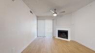 This single-floor residence offers a clean, functional layout with a cohesive design carried throughout by light wood-look flooring that runs seamlessly across every room. The living area serves as the central gathering space, highlighted by a classic white-surround fireplace and a sliding glass door dressed with vertical blinds that invite natural light and outdoor access. A ceiling fan with a built-in light fixture adds both comfort and practicality, while the textured ceiling adds a subtle design element overhead.

The galley-style kitchen is efficiently organized, featuring white cabinetry with brushed nickel hardware, granite-style countertops, and a full suite of stainless steel appliances including a refrigerator, electric range, and over-the-range microwave. The layout maximizes functionality within a compact footprint.

Two well-proportioned bedrooms each feature light-filled windows with horizontal blinds, offering a bright and airy atmosphere. The neutral wall tones and wood-look flooring continue throughout, maintaining a consistent and clean aesthetic.

The bathrooms are neatly appointed with white cabinetry, granite-style countertops, undermount sinks, and brushed nickel fixtures. One bathroom includes a full tub and shower combination with crisp white surround tiles, adding to the overall fresh and move-in-ready feel of the space.