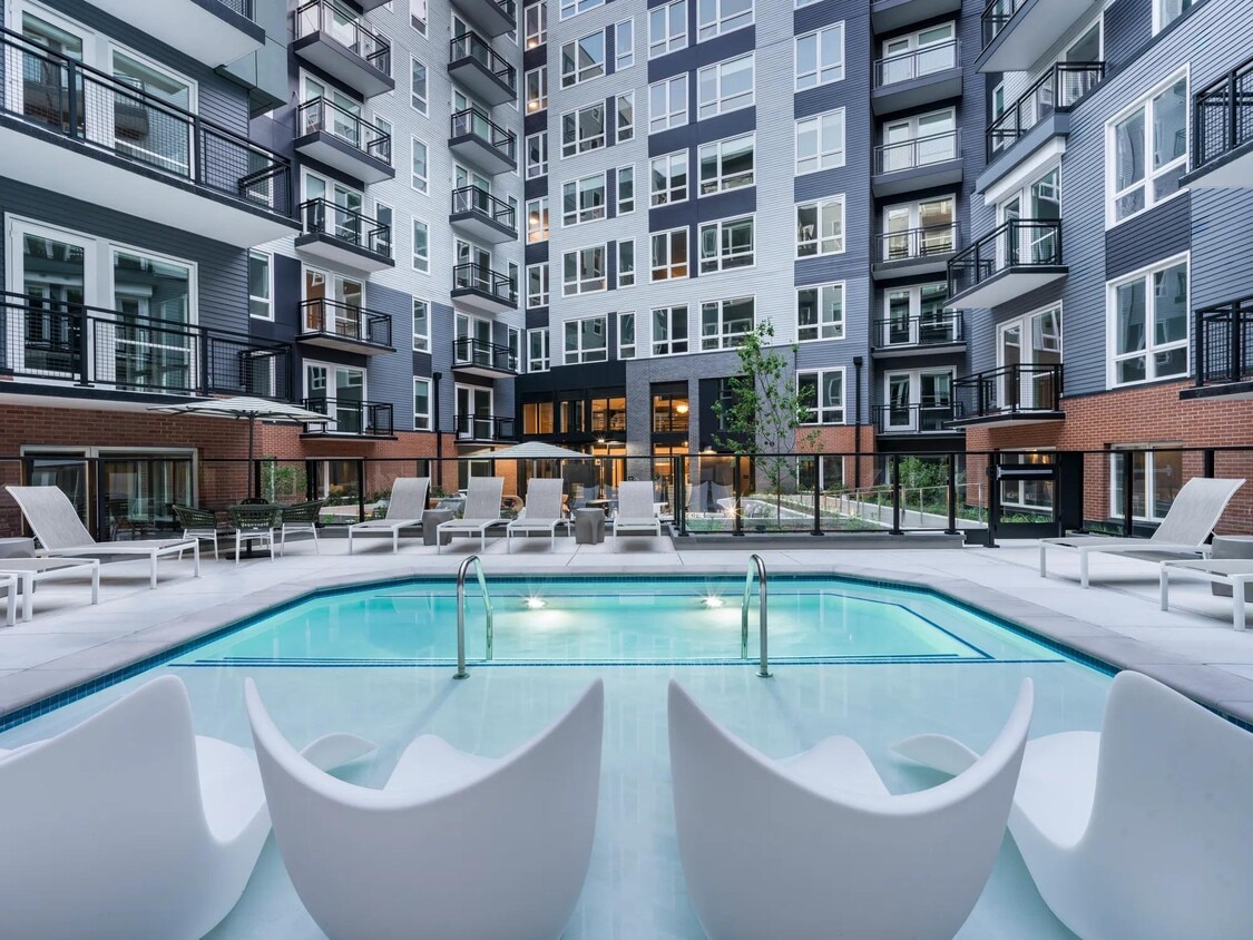 Soak, sun, and unwind in our resort-style courtyard pool, complete with in-water loungers, private seating, and a peaceful city backdrop. - Modera H Street