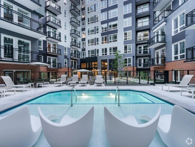 Soak, sun, and unwind in our resort-style courtyard pool, complete with in-water loungers, private seating, and a peaceful city backdrop. - Modera H Street
