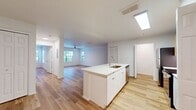 This contemporary 780 square foot apartment offers a thoughtfully designed living space on a single floor. The open-concept layout seamlessly integrates the kitchen, living, and dining areas, creating a spacious and airy feel. The kitchen is a standout feature, boasting stainless steel appliances, including a refrigerator, stove, and microwave, complemented by light-colored cabinetry and a sleek white backsplash.

The living area is generously sized, with ample room for both lounging and dining furniture. Large windows flood the space with natural light, while ceiling fans ensure comfortable air circulation. The bedroom, measuring 150 square feet, provides a cozy retreat with its own windows and ceiling fan.

The bathroom is modern and functional, featuring a single vanity with ample storage, a large mirror, and a toilet. Throughout the apartment, warm-toned hardwood flooring adds a touch of elegance and continuity. Additional amenities include a dedicated laundry area and a closet for extra storage.

The neutral color palette, dominated by whites and light wood tones, creates a bright and inviting atmosphere, allowing residents to easily personalize the space to their taste. This well-designed apartment offers a perfect blend of comfort and style for modern urban living.