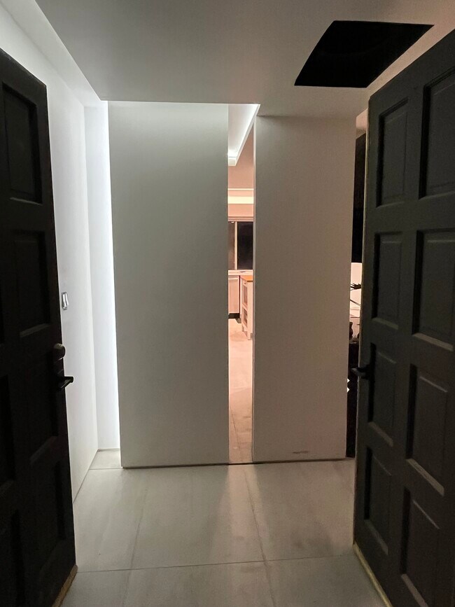 La entrada cuenta con una espectacular iluminación indirecta y una vista parcial a través de toda la casa hasta el patio trasero. - 5214 Dawes Ave