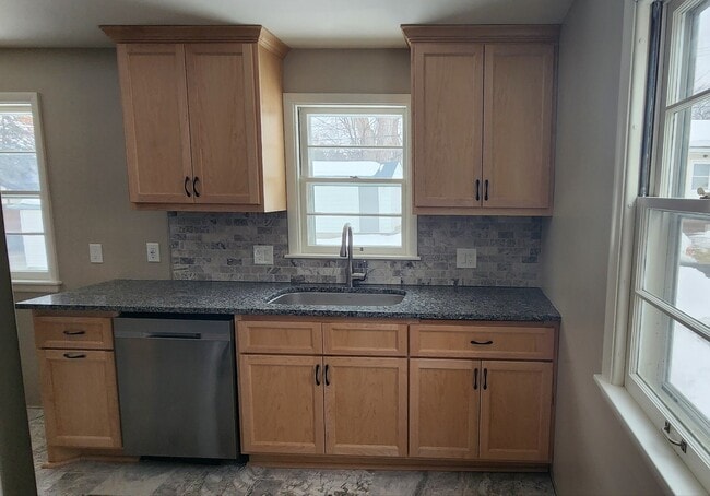 Maple and Granite Kitchen with a View of the Spacious Backyard - 3219 Taylor St NE