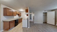 Located at 9189 Gale Blvd in Thornton, Colorado, this 2-bedroom, 1-bathroom unit offers a practical and comfortable single-floor layout. The living room is bright and welcoming, featuring light hardwood-style flooring, neutral beige walls, a textured ceiling, and a large window with vertical blinds that allow generous natural light to fill the space. A baseboard heating system is present throughout the unit for efficient warmth.

The galley-style kitchen is well-appointed with warm wood cabinetry, granite-look countertops, and white appliances including a range, refrigerator, and dishwasher. A washer and dryer are also accommodated within the kitchen corridor, adding everyday convenience.

Both bedrooms are carpeted and offer a cozy, quiet atmosphere. The primary bedroom is generously sized, featuring a large window with natural light, a built-in closet with double doors, and baseboard heating. The second bedroom is similarly finished with carpet, a window with outdoor views, and its own closet access.

The full bathroom is clean and functional, featuring a granite-look vanity with a wood cabinet base, a tiled tub-shower combination, and wood-style flooring. The unit also includes a hallway and dedicated closet for additional storage. Overall, the space presents a cohesive, neutral aesthetic throughout.
