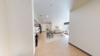 Located at Horizon in Bothell, WA, this 4-bedroom, 2-bathroom unit offers a well-organized single-floor layout designed for shared living. The modern kitchen features dark wood cabinetry extending to the ceiling, stainless steel appliances including a full-size refrigerator, dishwasher, and range, complemented by light hardwood-style flooring that flows throughout the common areas. The living room is bright and welcoming, anchored by a large floor-to-ceiling window that frames views of surrounding greenery and fills the space with abundant natural light. Clean white walls and a neutral palette create an open, airy atmosphere. Each of the four bedrooms is thoughtfully laid out to accommodate a bed with under-bed storage, a wardrobe or closet, and a dedicated study desk with chair — ideal for student living. Select bedrooms feature large windows with views of the outdoors, bringing in additional natural light. The two bathrooms are clean and functional, each equipped with a tub-shower combination, toilet, and light hardwood-style flooring. The overall design is contemporary and practical, offering a comfortable shared living environment well-suited for students at the University of Washington Bothell campus.