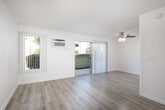 Located at 201 N Wayfield St in Orange, CA, this 2-bedroom, 1-bathroom unit offers a well-organized single-floor layout designed for comfortable everyday living. The open combined living and dining area is bright and airy, featuring light hardwood-style flooring, crisp white walls, a textured ceiling, and a ceiling fan with light fixture. A wall-mounted A/C unit ensures year-round comfort, while a sliding glass door opens directly onto a private patio with a teal-painted railing and views of lush greenery and well-maintained community grounds. The galley-style kitchen is thoughtfully appointed with white shaker cabinetry, granite-style countertops, a double stainless steel sink, and white appliances, complemented by a separate pantry for additional storage. Both bedrooms are carpeted and feature ceiling fans, vertical blinds, and mirrored sliding closet doors that maximize the sense of space. The bathroom includes a wide vanity with granite-style countertops, warm wood cabinetry, a large mirror, and hardwood-style flooring. A hallway connects all rooms efficiently, with multiple closets providing ample storage. The unit is completed by a charming patio that offers a peaceful outdoor retreat surrounded by greenery.