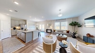 This two-story home in Navassa, NC offers a thoughtfully designed layout across two floors, with four bedrooms, four bathrooms, and a spacious attached garage. The main floor features an open-concept living, dining, and kitchen area bathed in natural light from multiple windows. The kitchen is outfitted with gray shaker-style cabinetry, granite countertops, stainless steel appliances, a center island with bar seating, and an adjacent pantry for ample storage. A sliding glass door off the dining area leads to the backyard, seamlessly connecting indoor and outdoor living. The living room provides generous space with hardwood-style flooring, large windows with sheer curtains, and a warm, welcoming ambiance. A dedicated laundry room with built-in shelving adds everyday convenience. Upstairs, the primary bedroom offers a comfortable retreat with a walk-in closet featuring wire shelving systems, complemented by three additional bedrooms — one of which is well-suited as a home office, with wide windows overlooking the surroundings. Throughout the home, clean neutral tones, consistent flooring, and crisp white trim create a cohesive, modern aesthetic. Five closets distributed across both floors ensure plentiful storage throughout.