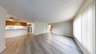 Located at 18427 Studebaker Rd in Cerritos, CA, this single-floor, 3-bedroom, 2-bathroom home offers a functional and well-appointed layout. The open living area features wood-look laminate flooring, a textured ceiling, and a wall-mounted air conditioning unit framed by vertical blinds that allow ample natural light. It flows seamlessly into the kitchen, which is equipped with warm honey-toned cabinetry, granite-style countertops, a stainless steel refrigerator, a gas range, and a peninsula that doubles as a serving counter. The three bedrooms are comfortably sized, with the primary bedroom offering generous closet space. Carpeted flooring and ceiling fans add comfort to the bedrooms, while mirrored sliding closet doors enhance the sense of space. The two bathrooms are cleanly finished — one features a glass-enclosed walk-in shower with white subway tile walls, while the second includes a shower-tub combination with a wood-toned vanity and granite countertop. A dedicated hallway and closet space round out the layout, ensuring practical storage throughout. The home presents a clean, neutral palette throughout, making it a versatile and move-in-ready residence.