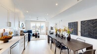 This contemporary residence is thoughtfully designed with a bright, open-concept layout that seamlessly connects the kitchen, dining, and living areas. Light hardwood flooring flows throughout, complementing the crisp white walls and recessed lighting that create an airy, welcoming ambiance.

The kitchen is outfitted with white shaker cabinetry accented by gold hardware, a striking marble-look backsplash, white quartz countertops, and a full suite of stainless steel appliances. It opens naturally into the dining area, which features a substantial dark wood table, and further into a generous living room anchored by floor-to-ceiling windows offering open urban views and fitted with a ceiling fan.

The bedrooms are serene retreats, each benefiting from large picture windows and corner glazing that invite abundant natural light and frame impressive cityscape panoramas, including notable historic architectural details of neighboring buildings.

The bathrooms are finished to a high standard, showcasing full-height travertine-style tile, frameless glass-enclosed walk-in showers, floating white vanities with undermount sinks, and consistently elegant brushed gold fixtures and fittings throughout. Recessed lighting and large mirrors enhance the sense of space and refinement. The overall design balances modern minimalism with warm, curated details.
