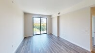 Located at 500 N Andrews Ave in the heart of Fort Lauderdale, FL, this well-appointed 2-bedroom, 2-bathroom residence offers a thoughtfully designed single-level layout. Wood-look flooring flows throughout the living areas and bedrooms, creating a warm, cohesive aesthetic against the neutral tones of the walls and trim.

The open-concept kitchen is a standout feature, showcasing sleek flat-front white cabinetry that extends to the ceiling, a marble-style tile backsplash, stainless steel appliances including a French door refrigerator and built-in microwave, and a generous island with pendant lighting overhead — ideal for both cooking and entertaining.

The primary bedroom is a spacious retreat with direct access to a private balcony through floor-to-ceiling sliding glass doors, framing views of the Fort Lauderdale skyline and surrounding greenery. The en-suite bathroom features large-format marble-look tile flooring, a frameless glass walk-in shower with marble tile surround, a wood-accented vanity with an integrated sink, and direct entry to a dedicated walk-in closet with wire shelving systems.

The second bedroom also enjoys city and treetop views through a large window, while the second full bathroom mirrors the refined finishes found throughout. Two closets provide ample storage across the residence.
