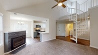 Located in Raleigh, NC, this two-story home on Chesterbrook Court offers a well-designed layout across two levels. The main living area makes an immediate impression with soaring vaulted ceilings, a ceiling fan, and plush carpeting. A fireplace anchors one end of the living room, while an opening leads to a private outdoor deck with brick accent walls, extending the living space outdoors. The open-concept design connects the living area to a thoughtfully updated kitchen featuring two-tone gray and white cabinetry, gleaming white countertops, stainless steel appliances, and hardwood-style flooring. A peninsula provides additional prep space, while an adjacent dining area is illuminated by a modern chandelier and benefits from ample natural light through large windows. A conveniently located bathroom on the main level showcases gray cabinetry, white countertops, and brushed nickel fixtures. The upper level, accessible via a white-railed staircase visible from the living area, hosts a generously sized bedroom with a walk-in closet outfitted with wire shelving. An additional full bathroom mirrors the refined finishes found throughout. A dedicated laundry area houses a full-size washer and dryer, adding everyday convenience to this well-appointed Raleigh home.