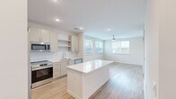Located at 2720 Bristlecone Trail in Raleigh, NC, this well-appointed 2-bedroom, 2-bathroom single-story residence offers a clean, modern aesthetic with a thoughtfully designed open floor plan. Light-toned hardwood-style flooring runs throughout, complementing the bright white walls and recessed lighting that keep the home feeling airy and inviting.

The kitchen serves as a central highlight, featuring a large white center island, sleek flat-front cabinetry extending to the ceiling, a classic subway tile backsplash, and a full suite of stainless steel appliances including a refrigerator with ice maker, electric range, built-in microwave, and dishwasher. The kitchen flows seamlessly into the living area, which benefits from multiple windows along the exterior wall, filling the space with natural light and offering outdoor views. A ceiling fan adds comfort to both the living area and each bedroom.

The bedrooms are generously sized, each with large windows that bring in ample daylight. The primary bedroom connects to a dedicated closet with wire shelving systems, offering organized storage solutions. The bathrooms are finished with white tiled tub-shower combinations. Hallways lined with louvered closet doors provide additional storage, completing this functional and modern Raleigh residence.