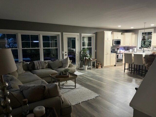 Sala de estar de diseño abierto con televisor de 75 pulgadas y cocina con encimera de cuarzo con electrodomésticos de acero inoxidable - 466 5th St