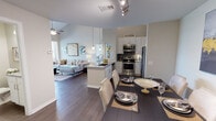 This two-story residence is thoughtfully designed with an open-concept layout on the main level that seamlessly connects the kitchen, dining, and living areas. The kitchen is outfitted with stainless steel appliances, white shaker cabinetry, granite countertops, a gray subway tile backsplash, and a peninsula with pendant lighting that doubles as a breakfast bar. Dark hardwood-style flooring flows throughout the main level, complementing the neutral color palette. The living room features soaring vaulted ceilings and a ceiling fan, creating an airy, expansive atmosphere. A half or full bathroom is conveniently accessible on the main floor. The primary bedroom offers high ceilings, plush carpet, a walk-in closet, and an en-suite bathroom complete with granite countertops, white cabinetry, and a tub-shower combination. Upstairs, a carpeted loft area with a ceiling fan and open railing overlooks the main level, offering a flexible space suitable for a home office or lounge. Additional rooms include a dedicated office or sitting room with multiple windows that fill the space with natural light. The overall ambiance is modern, clean, and welcoming throughout.