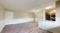 Located at 2312 Brightseat Rd in Hyattsville, MD, this single-floor 2-bedroom, 2-bathroom residence offers a well-organized layout across a comfortable footprint. The open living and dining area is finished with light-toned hardwood-style flooring and neutral, warm-toned walls accented by classic wainscoting chair rail detailing. A ceiling fan provides year-round comfort, while large multi-pane windows along the front of the unit invite generous natural light and outdoor views. The kitchen features warm wood cabinetry, granite-style countertops, a blue mosaic tile backsplash, and stainless steel appliances including a gas range and refrigerator, complemented by an in-unit washer. A peninsula counter separates the kitchen from the living area. The spacious primary bedroom offers ample room, hardwood-style flooring, and a window for natural light. The second bedroom includes a built-in closet with panel doors. Both bathrooms are well-appointed — one features a tub/shower combo with marble-style tile surround and sliding frosted glass doors, while the second offers a walk-in shower with clean, minimalist finishes and a wood-toned vanity with a white countertop.
