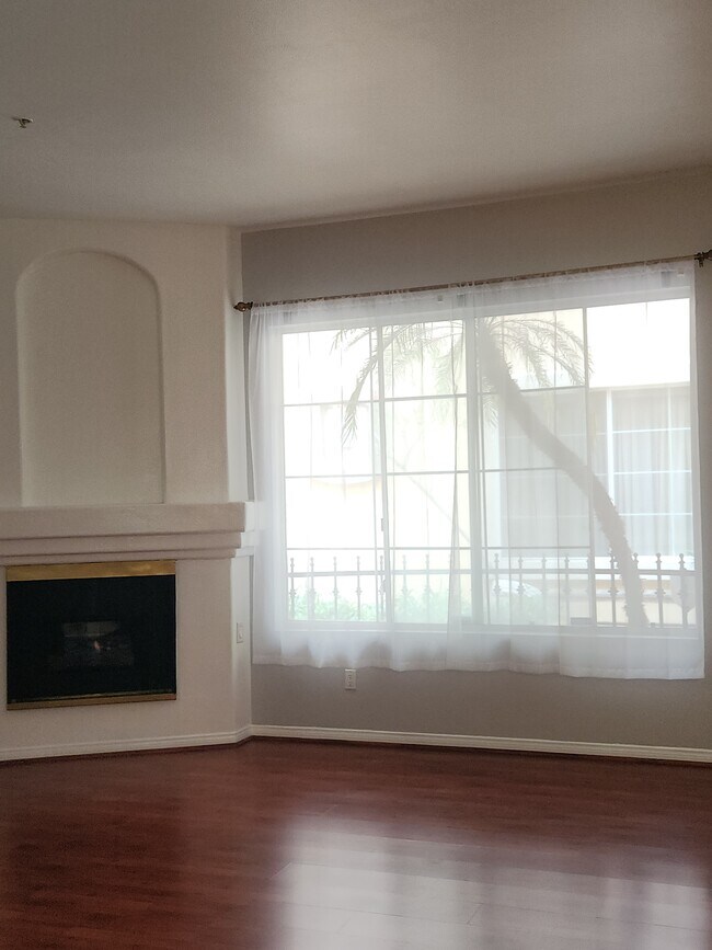 Living room with large window and fireplace - 7037 La Tijera Blvd