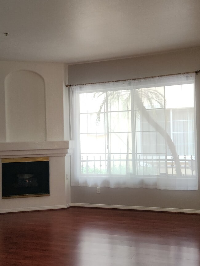 Living room with large window and fireplace - 7037 La Tijera Blvd