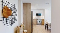 Located in Coney Island, Brooklyn, this thoughtfully designed 3-bedroom, 2-bathroom residence offers a clean, modern aesthetic throughout. Light oak hardwood flooring flows seamlessly across the single level, complementing the warm, neutral palette that defines each room.

The open-concept kitchen is a standout, featuring a two-tone design with white upper cabinetry and natural wood lower cabinets, white quartz countertops, a marble-style backsplash, and premium stainless steel appliances including a professional-grade range and French door refrigerator. The kitchen opens to a combined dining and living area, where floor-to-ceiling sliding glass doors lead to a private balcony with striking views of the Brooklyn skyline and surrounding waterfront.

The primary bedroom is a well-proportioned retreat with large windows offering sweeping outdoor views. The additional bedrooms maintain the same bright, airy character with light walls and ample natural light. Both bathrooms are finished with contemporary fixtures — one features marble-style tile walls, a glass-enclosed soaking tub, and a floating wood vanity with an oval backlit mirror. The second bathroom echoes the same refined simplicity. Additional conveniences include in-unit laundry, closet storage, and a hallway connecting all rooms efficiently.