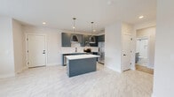 Located at 888 Horizon Boulevard in Athens, GA, this well-appointed 2-bedroom, 2-bathroom single-floor residence offers a thoughtfully designed open-concept layout with modern finishes throughout. The combined kitchen and living area serves as the heart of the home, featuring striking slate-blue cabinetry, white quartz countertops, a subway tile backsplash, stainless steel appliances, and a central island with pendant lighting accented by brass hardware. Marble-look tile flooring flows through the kitchen, while light hardwood flooring extends into the living area, which is finished with recessed lighting and a ceiling fan. A glass-panel door in the living space leads to an outdoor deck with a wooded view beyond. The primary bedroom is a comfortable retreat with dual windows inviting natural light, and both bedrooms are served by dedicated walk-in closets with wire shelving systems. A standout feature is one bedroom's shiplap accent wall, adding a modern farmhouse touch. The two bathrooms are finished with coordinating slate-blue vanities, white quartz counters, marble-look tile flooring, and subway-tiled tub-and-shower surrounds with matte black fixtures. Clean white walls and consistent finishes create a cohesive, contemporary ambiance throughout.