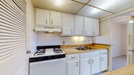 Located at 51 Grafton Ave in Dayton, Ohio, this single-floor unit offers a straightforward and functional layout well-suited for comfortable everyday living. The kitchen is equipped with white cabinetry spanning both upper and lower storage, a gas range with a ventilation hood, a double-basin stainless steel sink, and warm-toned countertops — providing ample workspace and storage for everyday cooking needs. A drop ceiling with integrated lighting keeps the kitchen area bright and practical.

The living areas feature neutral-toned carpeting throughout, creating a cohesive and easy-to-furnish environment. One carpeted room includes a ceiling fan with integrated lighting and louvered closet doors, offering both comfort and storage. A second carpeted room benefits from a window fitted with horizontal blinds that allows natural light and outdoor views. The spacious main living area opens through a sliding glass door to a private balcony, offering elevated views of the surrounding neighborhood and greenery — a standout feature of the space.

The bathroom is clean and efficiently arranged, featuring a vanity with cabinet storage, a medicine cabinet with mirror, a toilet, and tile flooring. The overall layout, as seen in the dollhouse view, flows logically between the kitchen, living spaces, and bathroom, making for a practical and livable single-floor home.