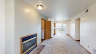 Located at 4000 Hyde Park Ave in Columbia, Missouri, this single-floor residence offers a well-organized and functional layout designed for comfortable everyday living. The spacious living room serves as the heart of the home, featuring plush wall-to-wall carpeting, a textured ceiling, and a classic fireplace with a brick hearth and gold-trimmed glass doors — a standout focal point that adds warmth and character to the space. A sliding glass door at the far end of the living area provides direct access to an outdoor patio and fills the room with natural light. The kitchen is efficiently designed with warm oak cabinetry, dark granite-style countertops, a double-basin sink, and wood-look flooring, complemented by a window that brings in additional daylight. In-unit laundry is conveniently tucked nearby. The bedrooms are carpeted and bright, each featuring windows with blinds and ample closet space, including sliding-door wardrobes for organized storage. The bathroom is clean and straightforward, equipped with a full tub-shower combo, wood-look flooring, and a vanity. Warm wood trim and neutral tones throughout create a cohesive, inviting atmosphere across the entire residence.