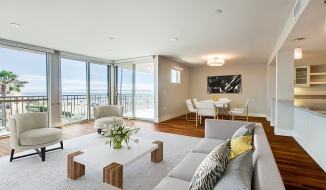 Relaxing living room complete with wood flooring, large patio doors, and plenty of natural light - Ocean House on Prospect Apartment Homes