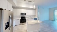 Located at 101 W Camino Real in Boca Raton, FL, this modern residence offers four bedrooms, three bathrooms, and a thoughtfully designed single-floor layout. The contemporary kitchen serves as a central highlight, featuring sleek flat-panel white cabinetry extending to the ceiling, stainless steel appliances, a central island with a crisp white countertop, and a combination of pendant and track lighting that creates a bright, functional workspace. Light wood-look flooring flows consistently throughout the home, enhancing the clean, cohesive aesthetic. The bedrooms are bright and well-proportioned, with several rooms benefiting from natural light through large windows framing lush outdoor greenery and tropical landscaping. The primary bedroom includes dedicated closet space with wire shelving for organized storage. The bathrooms are finished with large-format, neutral-toned tile work — one bathroom features a frameless glass walk-in shower, while another includes a soaking tub, both showcasing modern chrome fixtures. Crisp white walls and tray ceiling details throughout add architectural dimension, while ceiling fans in the bedrooms provide added comfort. Two closets further enhance the storage capacity of this well-appointed Boca Raton residence.