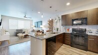 Located at 4333 N 6th Dr in Phoenix, AZ, this one-bedroom, one-bathroom residence offers a well-designed, single-floor layout with a thoughtful blend of modern finishes and functional living spaces. The open-concept main area seamlessly integrates the kitchen, dining, and living room, creating a cohesive and airy atmosphere. The kitchen is a standout feature, showcasing rich dark wood cabinetry, granite countertops, a peninsula with bar seating, pendant lighting, a tiled backsplash, and black appliances including a range, microwave, dishwasher, and refrigerator. Light wood-style flooring runs through the kitchen and main areas, complementing the clean, contemporary aesthetic. The living room features plush carpeting, a ceiling fan, and large windows that invite abundant natural light. The bedroom is a comfortable retreat with carpeted floors, a ceiling-height sliding glass door opening to a private balcony with outdoor views, and a dedicated closet. The bathroom offers a full soaking tub and shower combination, a dark wood vanity with a white countertop, and matching wood-style flooring. The private balcony provides a pleasant outdoor extension of the living space, ideal for enjoying the Arizona climate.