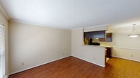 This single-story, two-bedroom, one-bathroom residence in Houston, TX offers a practical and well-organized layout. The living area serves as the heart of the unit, featuring warm hardwood-style flooring, crown molding, and a textured ceiling. A large window fitted with horizontal blinds allows natural light to fill the space, while a white panel entry door provides a welcoming point of arrival.

The kitchen is positioned adjacent to the living area and is accessible via a pass-through counter with light granite-style countertops. Dark espresso cabinetry lines the walls, providing ample storage, while stainless steel appliances—including a refrigerator and dishwasher—add a modern touch. The kitchen floor is finished in neutral tile.

Both bedrooms are carpeted for comfort and each includes a ceiling fan with integrated lighting. One bedroom features a closet with panel doors, while the other benefits from a window with blinds that invites natural light. The shared full bathroom includes a granite-topped vanity with dark cabinetry, tile flooring, and a tub-shower combination enclosed by a panel door, offering a clean and functional layout throughout.