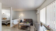 Located at 919 East Lemon Street in Tempe, Arizona, this one-bedroom, one-bathroom unit offers a efficient, single-floor layout designed to maximize every square foot. The living room serves as the heart of the space, showcasing a distinctive painted concrete block accent wall that adds texture and character. Wood-look flooring runs throughout, creating a cohesive and easy-to-maintain surface. A window with vertical blinds allows natural light to filter in, while a wall-mounted AC unit ensures comfort year-round. The textured ceiling is a consistent architectural detail found throughout the unit.

The bedroom continues the painted brick wall aesthetic, providing a cozy and well-defined retreat. It includes closet storage and direct access to the bathroom, enhancing practicality. The bathroom features a clean, white vanity with mirror, a combination tub and shower enclosed by sliding frosted glass doors, and matching wood-look flooring that ties the space together.

A dedicated area near the entry accommodates a desk setup, making the unit well-suited for students or remote workers. Its location near Arizona State University makes it an ideal option for those seeking a straightforward, low-maintenance living space in the heart of Tempe.