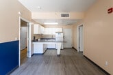Located at 1100 Everton Pl in Riverside, California, this single-floor unit offers a well-organized layout with a consistent, clean aesthetic throughout. The open-concept kitchen serves as a central hub, featuring white cabinetry, gray stone-finish countertops, a gas range, a full-size refrigerator, and an over-the-range microwave. A peninsula counter extends outward, providing additional workspace and creating a natural divide between the kitchen and the adjacent living area. A bold blue accent wall adds a distinctive visual element to the shared living space, which receives natural light through vertical blinds.

The bedrooms are generously proportioned, each finished with warm beige walls, dark baseboards, and light gray wood-look flooring that runs consistently throughout the unit. Closet access is visible from the bedroom areas, offering practical storage solutions. HVAC vents are present in the ceilings, ensuring climate control.

The unit includes two bathrooms, each equipped with a vanity featuring gray countertops, under-sink cabinetry, a large mirror, and wood-look flooring. One bathroom includes a full tub-shower combination with a curtain rod, while the second offers a similar layout with accessible design features. Overall, the unit presents a functional and cohesive living environment.
