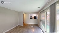 Located at 4010 Twickenham Ct in Raleigh, NC, this one-bedroom, one-bathroom unit offers a well-organized single-floor layout designed for comfortable everyday living. The living room serves as the heart of the home, featuring warm wood-look laminate flooring, neutral grey-toned walls, and a sliding glass door that invites natural light and provides outdoor access. A pass-through opening connects the living area to the kitchen, which is equipped with white cabinetry, a tile backsplash, and black appliances, creating a functional yet open feel. The bedroom is a comfortably sized retreat finished with soft carpet flooring and a window fitted with blinds that allow for natural light and privacy. A dedicated closet offers convenient personal storage. The hallways connect each area of the unit efficiently, maintaining a smooth flow throughout. The bathroom features a white vanity with a granite-style countertop, a large mirror with a multi-bulb light fixture above, built-in open shelving for additional storage, and tile flooring. Textured ceilings are consistent throughout the unit, and clean white baseboards provide a crisp finishing detail. The overall aesthetic is clean, neutral, and move-in ready, making this a practical and comfortable home in Raleigh.