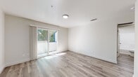 This well-appointed single-floor unit in Sacramento, CA (95821) offers a clean, modern aesthetic throughout. Light-toned wood-style flooring runs continuously across the living areas, bedrooms, and hallways, creating a cohesive and airy feel. The open living area is filled with natural light streaming through a sliding glass door that leads to a private balcony overlooking lush greenery, offering a pleasant outdoor connection. The kitchen is thoughtfully designed with white shaker-style cabinetry, granite-look countertops, a peninsula breakfast bar, and a full-size refrigerator, combining functionality with a bright, contemporary look. A dedicated hallway connects the bedrooms and bathrooms, providing a practical layout. The bedrooms are well-proportioned, with one featuring a sliding-door closet with built-in shelving and rod, and another offering a window with natural light. Two full bathrooms are finished in a crisp white palette, each featuring a tub-shower combination, white vanity cabinetry, and brushed nickel fixtures. The unit's neutral color scheme, updated finishes, and efficient floor plan make it a clean and functional space suited for everyday living.