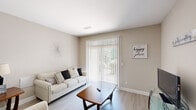 Located at 300 Caughman Farm Ln in Lexington, SC, this single-story, 3-bedroom, 2-bathroom home offers a well-organized and comfortable layout. Light-toned walls and wood-look flooring run throughout the main living areas, creating a cohesive and airy atmosphere.

The living room is bright and welcoming, featuring a sliding glass door with vertical blinds that provides direct outdoor access and fills the space with natural light. Adjacent to the living area, the dining room offers an intimate setting highlighted by a pendant light fixture overhead. A utility closet is conveniently accessible from this area.

The kitchen is efficiently designed with warm wood cabinetry, a tile backsplash, dark countertops, recessed lighting, and a peninsula with sink — ideal for both cooking and casual dining. Black appliances including a refrigerator, range, and over-the-range microwave complete the space.

The primary bedroom is a comfortable retreat with carpeted flooring, natural light from a window with blinds and curtains, and a ceiling fan. It connects to a walk-in closet with wire shelving and leads to a full bathroom featuring a tub/shower combination with grab bars. A second full bathroom serves the remaining two bedrooms, rounding out this practical and well-appointed home.