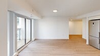 Located at 375 South Street in London, Ontario, this 2-bedroom, 1-bathroom unit offers a clean, modern design with a practical and well-organized layout. Light-toned laminate flooring runs throughout the living areas and bedrooms, complementing the crisp white walls and creating a bright, cohesive feel. The open-concept kitchen is outfitted with contemporary cabinetry and stainless steel appliances, flowing naturally into the living area, which features sliding glass doors that invite natural light and provide outdoor access. The generously sized primary bedroom is a standout feature, boasting floor-to-ceiling corner windows that frame sweeping views of the London skyline and surrounding neighbourhood, filling the room with abundant natural light. The second bedroom also benefits from large windows overlooking the cityscape. The bathroom is finished with large-format grey tile flooring, a combined tub and shower, a wall-mounted storage cabinet, and a vanity with an undermount sink and mirror. Central to the unit's appeal is its elevated position, offering panoramic urban views from multiple rooms. The overall aesthetic is clean and contemporary, making this a well-appointed space in the heart of London, Ontario.